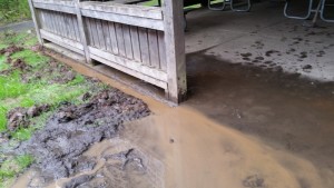 Mud and silt flowing over the cement pad