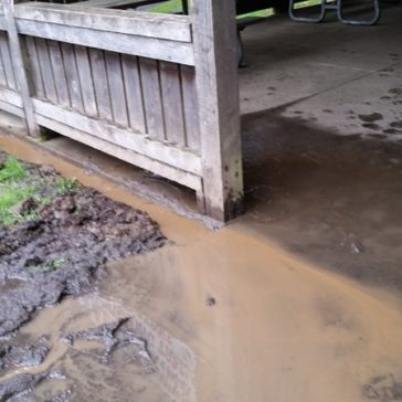 Mud and silt flowing over the cement pad